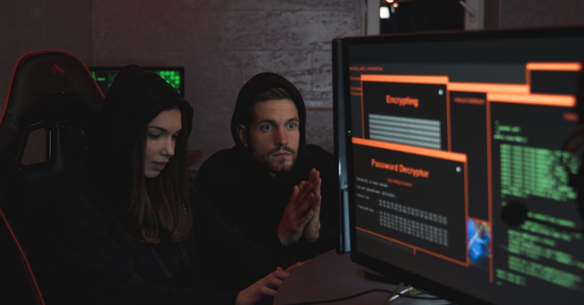 Cybersecurity experts in hoodies analyzing encrypted data on computer screens in an indoor setting.